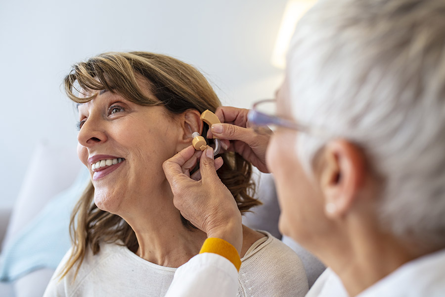 Dental, Vision, and Hearing Plans - Doctor Adjusting Hearing Aid of a Senior Patient in Her Office